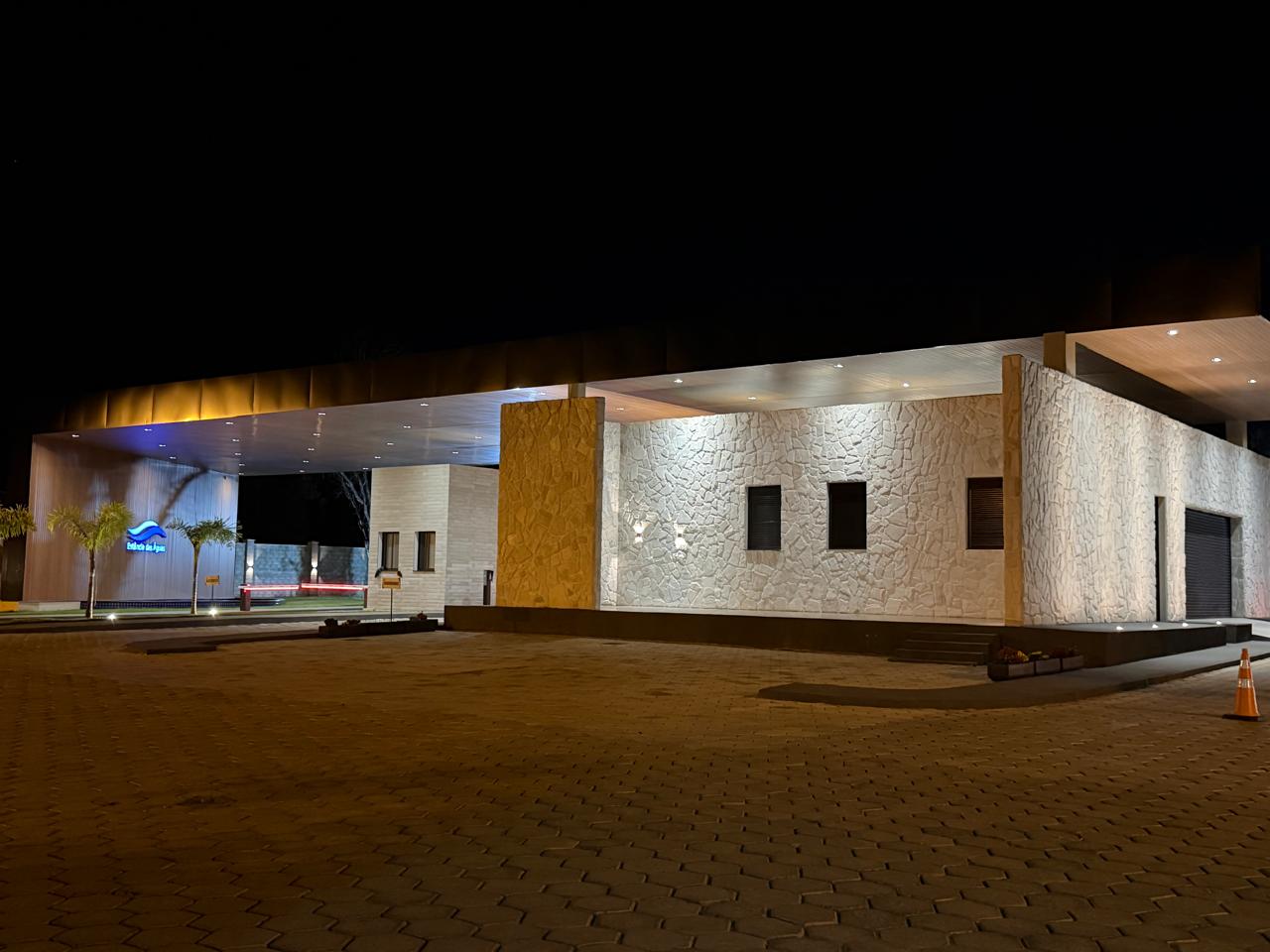 Fachada da portaria iluminada à noite, vista lateral